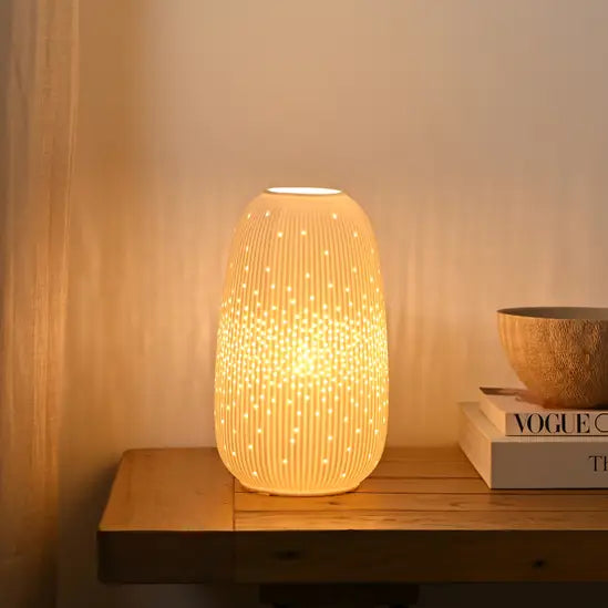 Decorative lamp with ribbed texture on a wooden surface, emitting a warm glow.